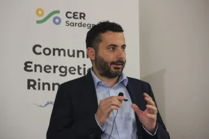 Ass.re M.Leccis Cocco Ortu al microfono. Ha corti capelli scuri e ricci, barba media, giacca scura e camicia azzurra