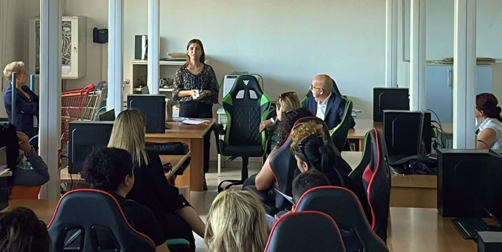 Un momento dalla presentazione del corso OSS a Sorso. Una giovane donna si rivolge alle partecipanti, che sono sedute di fronte a lei.