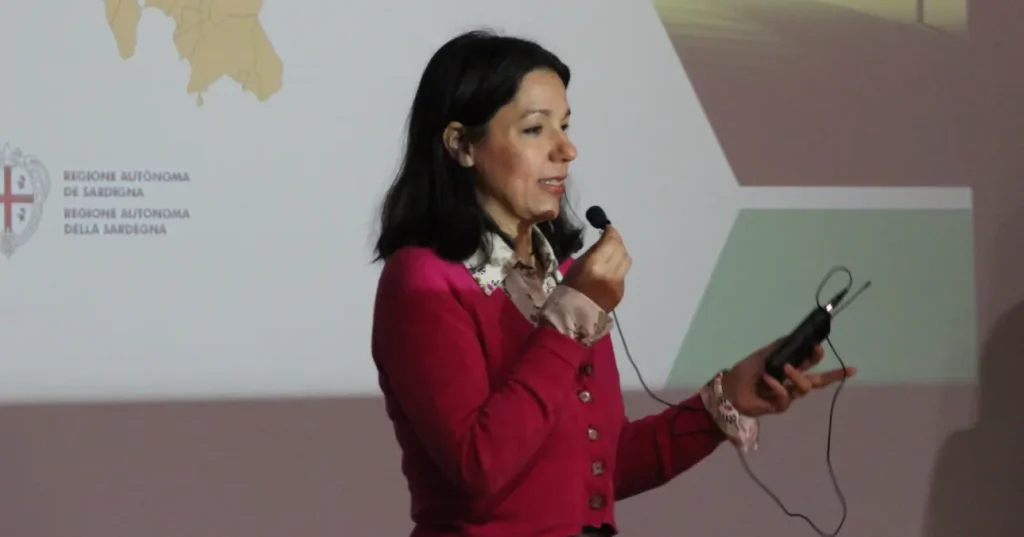 CER Sardegna - Serrenti seminario n5- Enrica Puggioni al microfono durante l'incontro. Ha i capelli scuri lisci e un maglione rosso.