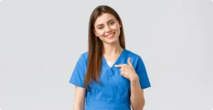 Corso OSS (Operatore Socio Sanitario) Cagliari. Ragazza sorridente con camice azzurro e capelli lisci castani sino alle scapole.